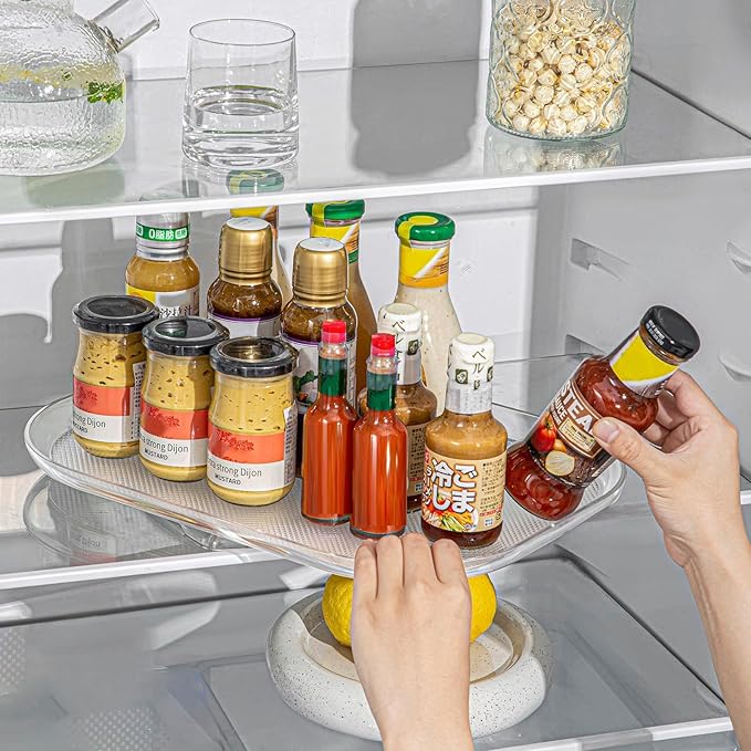 Person using a refrigerator shelf organizer with various condiments in a kitchen.