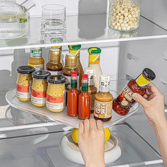 Person using a refrigerator shelf organizer with various condiments in a kitchen.